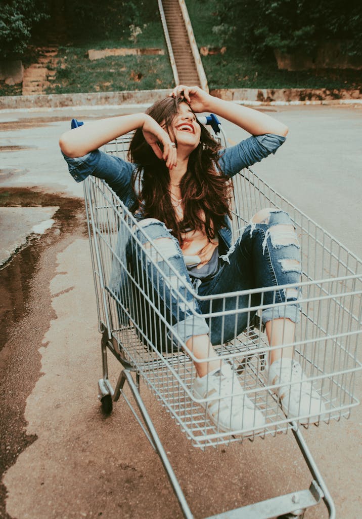 Photo of Woman Sitting in Shopping Cart